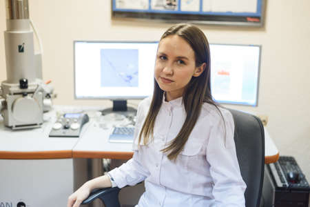 Young scientist works in modern biological lab. Happy young female researcher working at desk using computer in the laboratoryの写真素材