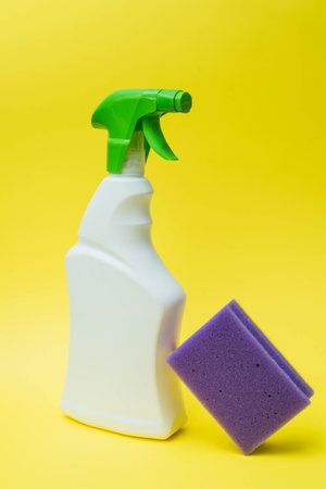 Detergent, sponge and gloves for cleaning the house on a yellow bright background. The concept of cleaning, cleansing and bleachingの写真素材