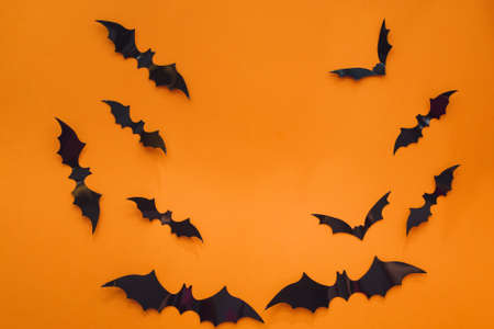 Halloween background. Bats on an orange background. Flat lay, copy spaceの写真素材