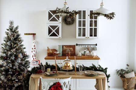 The interior of the modern kitchen is decorated for Christmas. Christmas tree in the kitchen.の写真素材