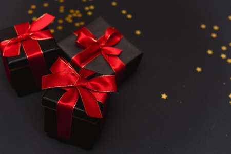 Beautiful Christmas golden snowflakes with gifts on a dark black background. Flat lay. Copy space.の写真素材