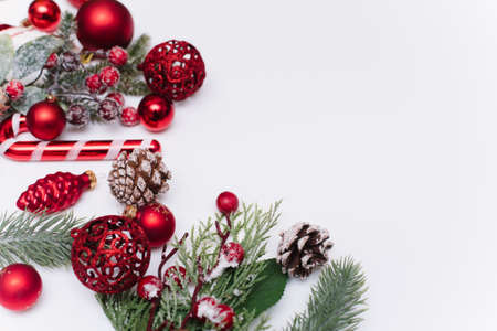 Christmas composition with fir branches, red decorations on a white background with copy space for your text. Christmas, winter, new year concept. Flat lay, top view, copy spaceの写真素材