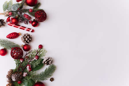 Christmas composition with fir branches, red decorations on a white background with copy space for your text. Christmas, winter, new year concept. Flat lay, top view, copy spaceの写真素材