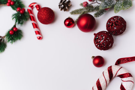 Christmas photo of branches of a tree with red toys and balls on a white backgroundの写真素材