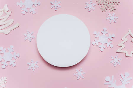 Christmas composition with white decorations on a pink background. Blank white paper circle shape....