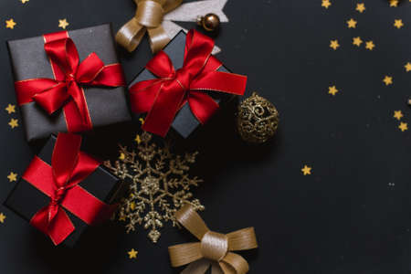 Beautiful Christmas golden snowflakes with gifts on a dark black background. Flat lay. Copy space.の写真素材