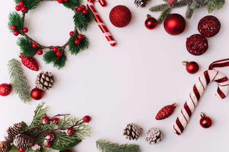 Christmas frame made of fir branches, red decorations for the tree. Christmas wallpaper. Flat lay, top view, copy spaceの写真素材