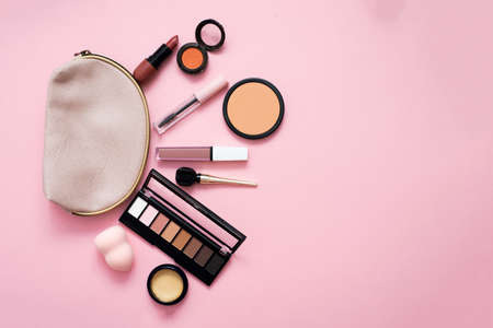 Decorative cosmetic set from a pink cosmetic bag on a light background. Copyspace. Makeup artists...