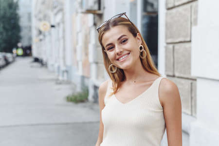 Happy young beautiful woman walking on the street. Image of beautiful stylish womanの写真素材