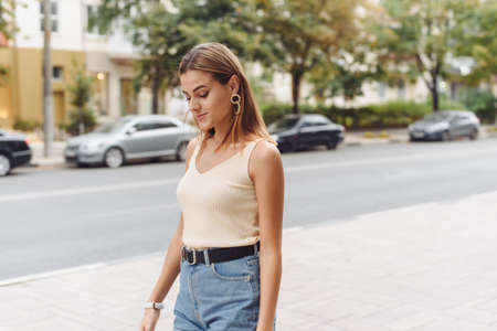 Portrait of a beautiful young woman walking in the street. Woman with beautiful earringsの写真素材