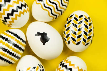 White eggs with a geometric gold and black pattern on a white background.の写真素材