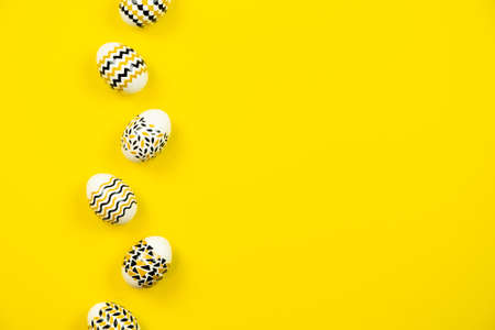 White eggs with a geometric gold and black pattern on a white background. Copy space. Flat layの写真素材