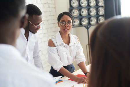 African american female ceo leading corporate multiracial team meeting talking to diverse businesspeople, black woman executive discussing project plan at group multi-ethnic briefing in officeの写真素材
