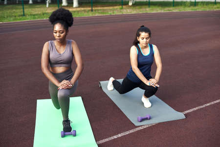 Active lifestyle in the city. Image of young women doing stretching after running workoutの写真素材