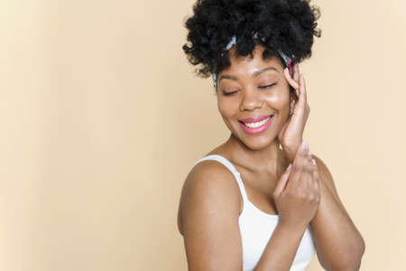Skin care. Beauty portrait of a black woman looking away on a beige background. Copy Space.の写真素材