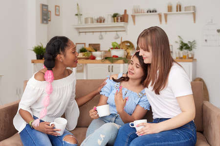 An unhappy woman talks about her problems to her friends at home. The concept of friendship and support.の写真素材