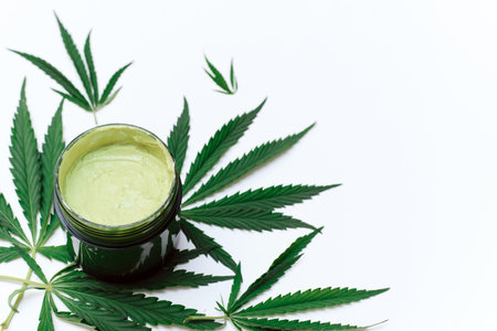 Green clay mask with hemp extract on a white background with copy space. use of cannabis in the creation of cosmetics.の写真素材