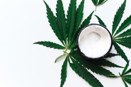 Moisturizing cream with hemp oil on a white background with copy space. The use of cannabis in the production of cosmetics for skin careの写真素材