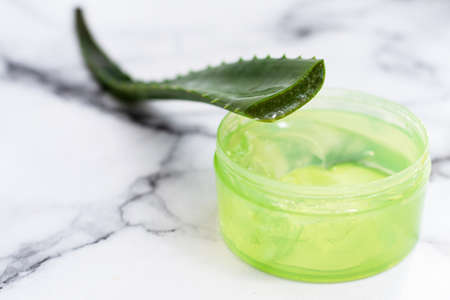 Aloe leaf and gel on a marble background with copy space. Moisturizing, recovery and caring for the skin.の写真素材