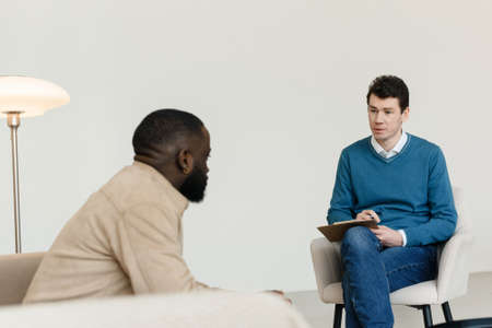 An African-American man talks to a psychologist about his problems. Psychological help service.の写真素材