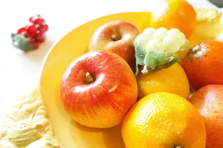 Red apple in a bowl of assorted and colorul fruitの写真素材