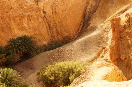View of a welcome message on the mountain of Chebika oasis in Tunisiaの写真素材