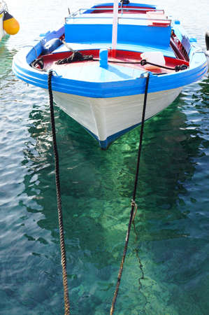 Moored white fishing boat on crystalline sea in sicilyの写真素材
