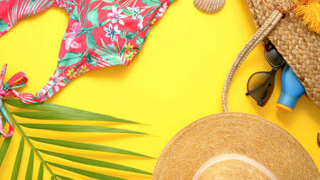 Summer background with seashell, beach hat and palm leaf on yellow background. beach vacation and traveling conceptの写真素材