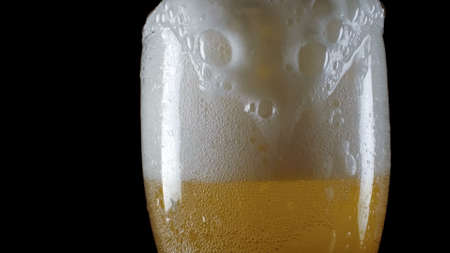 Closeup of glass of champagne with foam on a black backgroundの写真素材