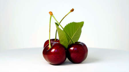 Three cherries on a white backgroundの写真素材