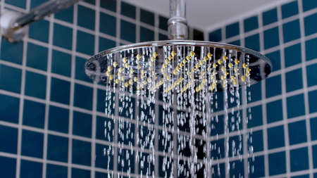 Shower Head With Drops Of Water Falling Down in bathroomの写真素材
