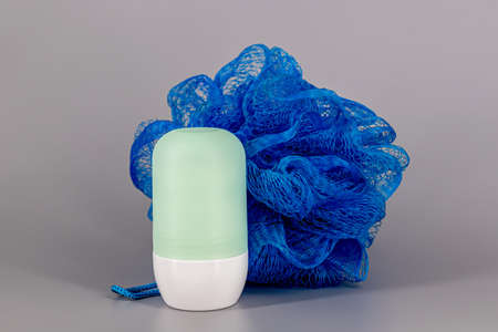 Roll On deodorant - Two plastic container with sphere applicator, Blue and Turquoise witha a shower or bath sponge in nylon for scrub on a neutral background - Isolatedの写真素材