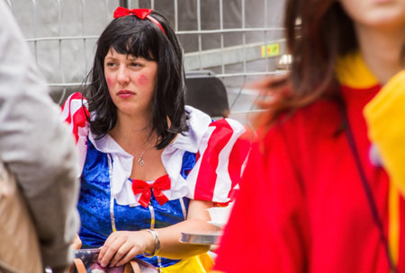 Tenerife, Spain - 17-02-2015: Tenerife Carnival - Boring Snow White disguised girl seated waiting someone.のeditorial素材