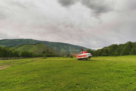 helicopter in the mountains on the field in the summer in a thunderstormの写真素材
