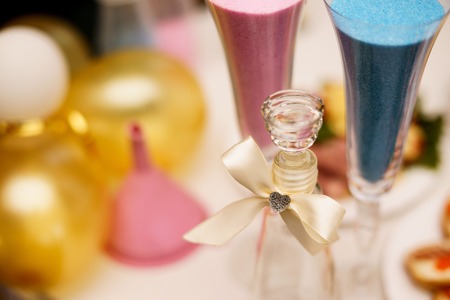 Sand ceremony on wedding, glass vase for bride and groom. Marriage concept. Pink and blue