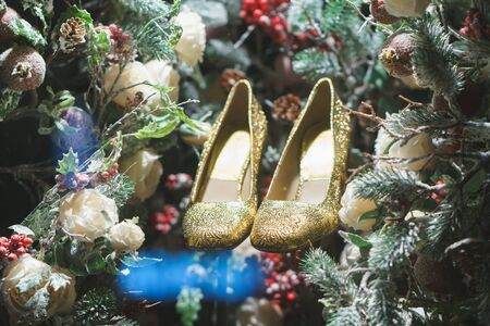 golden shoes in Christmas tree, snow and decorationsの写真素材