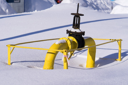 big cock on the gas pipe in the winter on the snow. sunshineの写真素材