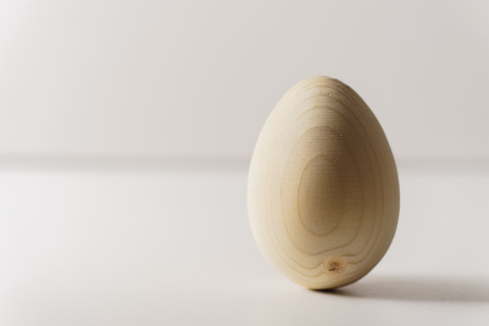 one wooden egg on white background, close upの写真素材