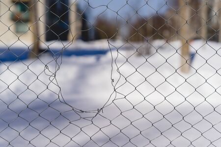 a hole in the mesh fence. winterの写真素材
