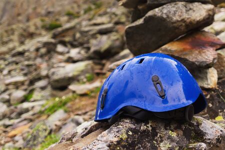 one protective climbers helmet on the rock. the blue one helmets on the mount.の写真素材
