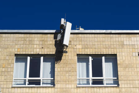 antenna mobile operator on the wall on blue sky.