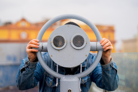 fun ideas. man looks through his binoculars on the lookout closeupの写真素材