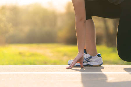 girl runner at the start on asphalt treadmill