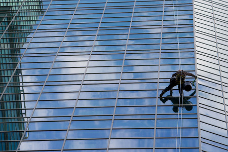 Industrial mountaineering worker wash windows of a high-rise buildingの写真素材