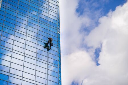 Industrial mountaineering worker wash windows of a high-rise buildingの写真素材
