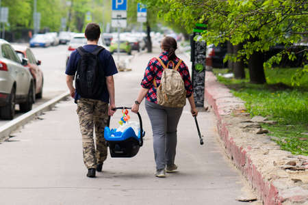 Moscow, Russia, 19 may 2017: parents go on the sidewalk and bear his child