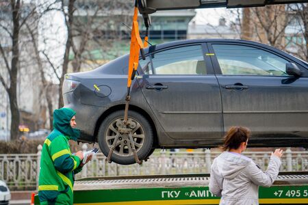 MOSCOW RUSSIA - APRIL 22 2017: Traffic police officers on the street wants lifting the car on the tow truck for taking awayのeditorial素材