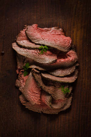 Juicy roast beef slices on cutting boardの写真素材