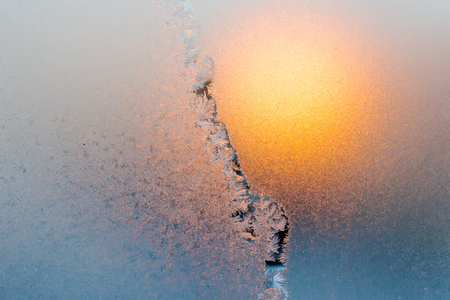 Frozen window. Sun light from ice.の写真素材