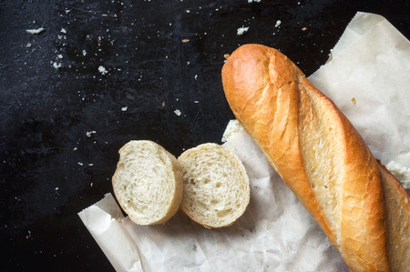 French baguette on paper. Dark background